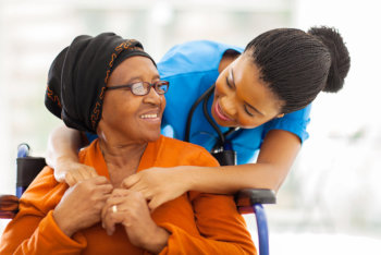 caregiver assisting elderly woman in hospital