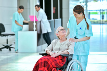 caregiver assisting elderly woman in hospital