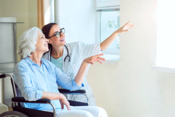 caregiver and elderly woman pointing at the window